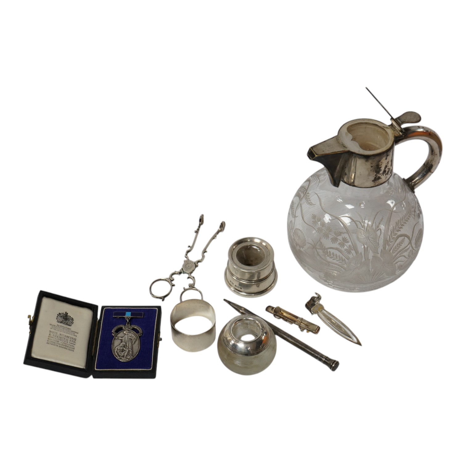 A pair of mid 18th century silver sugar nips, by Alexander Osborne, London, circa 1765, 11.6cm, together with a silver mounted glass match strike, a silver mounted inkwell, a silver napkin ring, a cased silver medallion